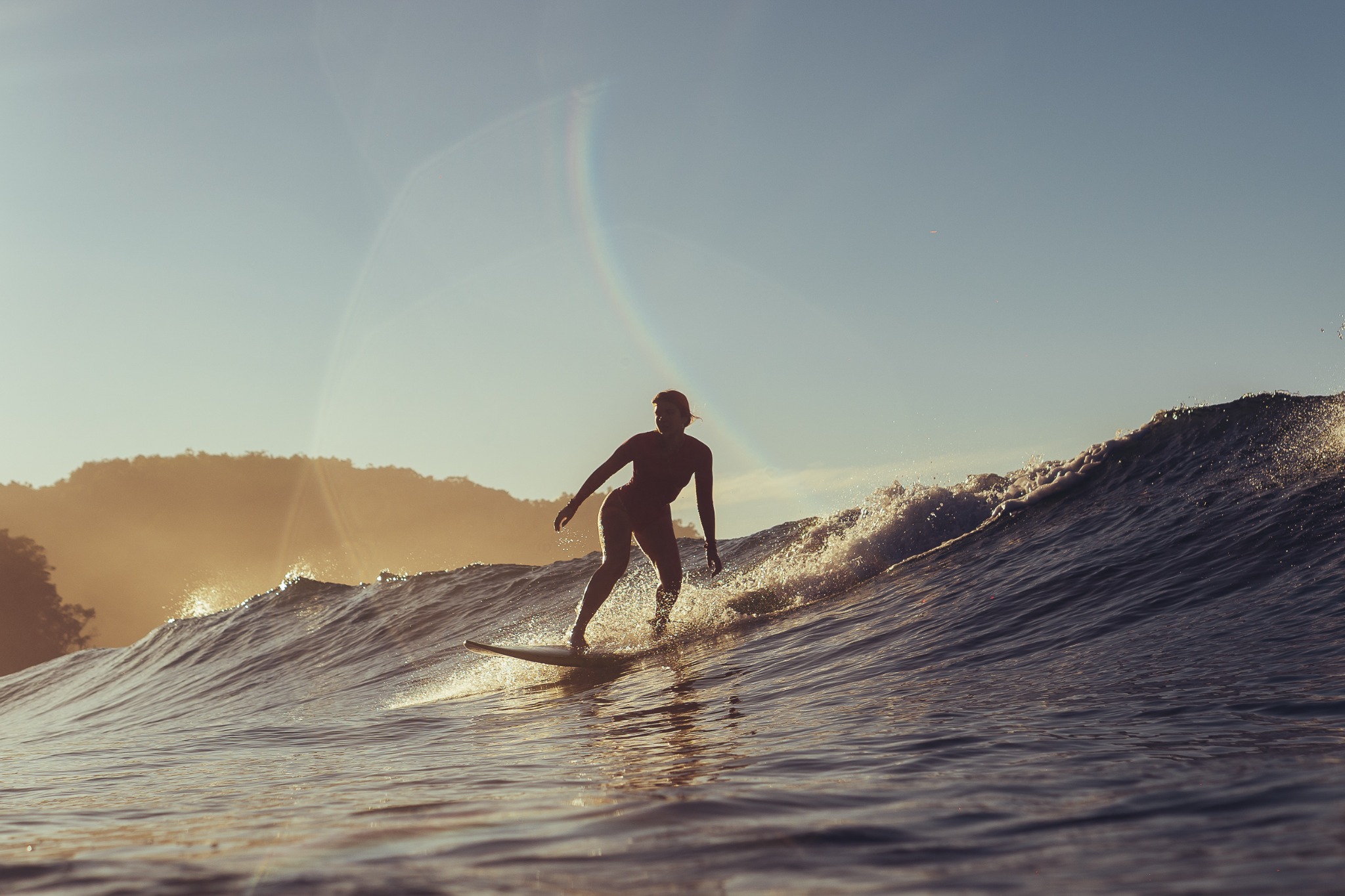 Surfista deslizando em uma onda sob a luz do sol